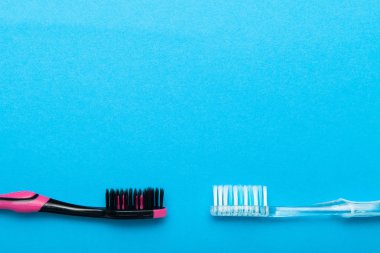 Mavi arka plan üzerinde renkli plastik diş fırçası. Boş kopya spa