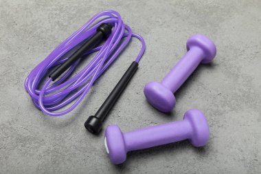 Menekşe dumbbell ve ip bir beton zemin üzerine.