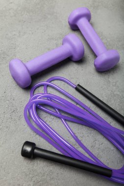 Spor spor için gri arka plan üzerinde ip ve ağırlıkları atlama