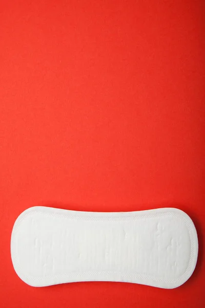 A nők menstruációs pad vörös háttérben, másol hely. — Stock Fotó