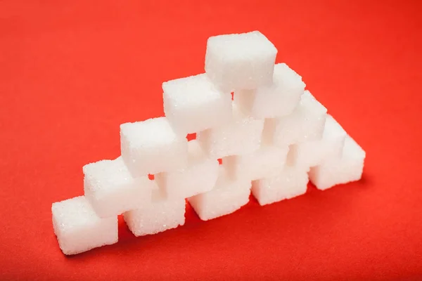 Pirâmide de açúcar em um fundo vermelho . — Fotografia de Stock