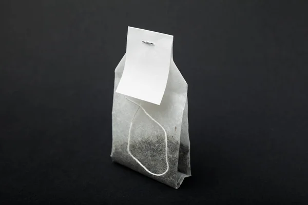 Saco de chá branco em um fundo preto. Layout para design de embalagens — Fotografia de Stock
