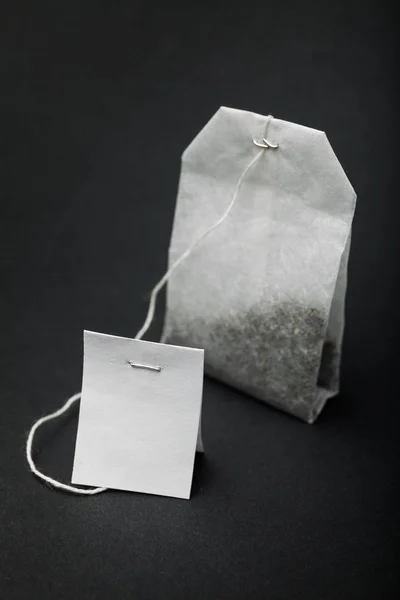 Logo du thé vide et sac en papier sur fond noir . — Photo