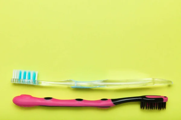 Toothbrushes on yellow background, copy space. — Stock Photo, Image