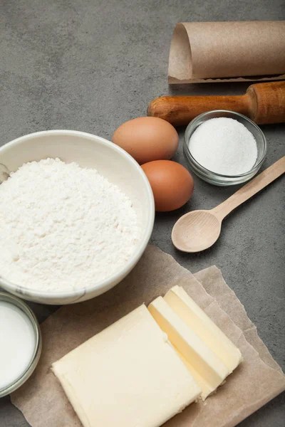 Grijze keukentafel met keukengerei en ingrediënten voor bakken. — Stockfoto