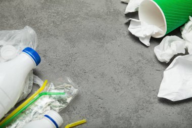 Bir plastik şişe, plastik ve kağıt üzerinde gri bir backgro ile atık