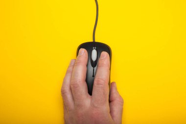 Bilgisayar fare sarı bir arka plan üzerinde bir erkek elinde.
