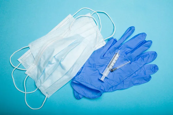Sterila mask, spruta och handskar på en blå bakgrund. — Stockfoto