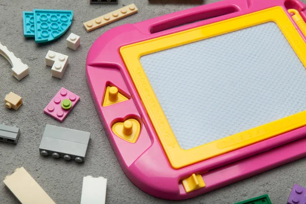 Pink plastic magnetic drawing board, toy for learning to draw.