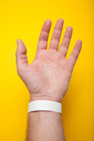 Blank mockup bracelet on hand, isolated on yellow background. Co — Stock Photo, Image
