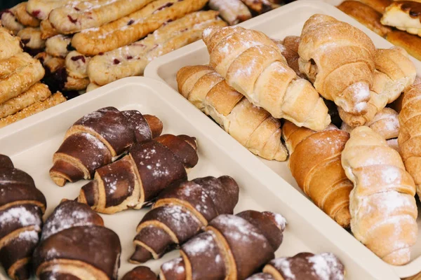 Dükkan vitrininde çikolata ve kremalı kruvasan.