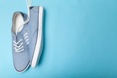 Mavi arka planda gündelik spor ayakkabılar, metin için kopya alanı.