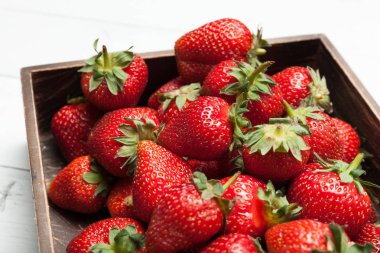 Kutuda taze kırmızı çilek, olgun berry kazık.