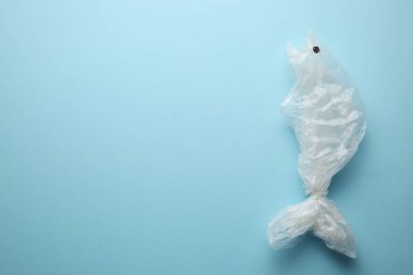 Okyanustaki çöp, plastik bir torbadan çıkan balık silueti..