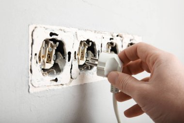 Duvardaki elektrik prizindeki kablolar hasar görmüş. Elektrinin ihlali