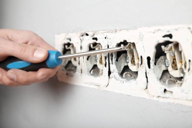 Duvardaki elektrik prizindeki kablolar hasar görmüş. Elektrinin ihlali