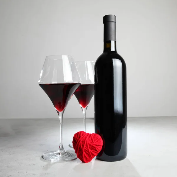 Fles wijn en een rood hart Liefde en romantiek. — Stockfoto