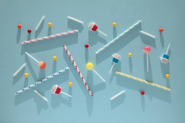 Çocuk doğum günü partisi, mavi arka plan (desen). Tatlı şekerler, parlak balonlar, şenlikli mumlar, kek ve pipetler..