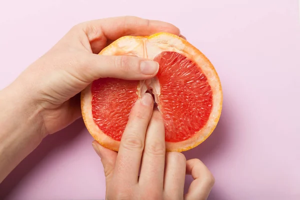 Two female fingers in grapefruit, woman masturbation and sex concept. Vagina and clitoris symbol.