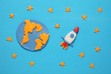 Uzayda roket, yıldız, gezegen, dünya ve ay. Plastik sanat, çizgi film.