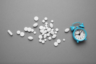 Uyku hapları ve çalar saat, uykusuzluk konsepti. Stres ve uyku sorunları.