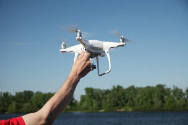Mavi gökyüzü arka planında İHA. Fotoğraf makinesi olan uzaktan kumandalı kuadrokopter. Uçan robot..