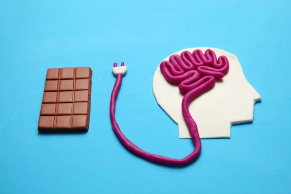 Bir erkek figürü ve bir kalıp çikolata. Zihin için besleyici beyin enerjisi.