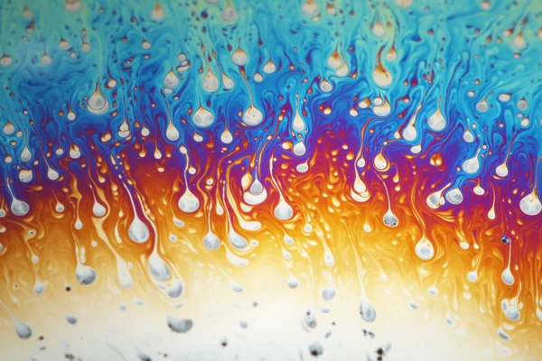 Multicolored rainbow soap bubble, psychedelic background. Abstract liquid colors and texture.