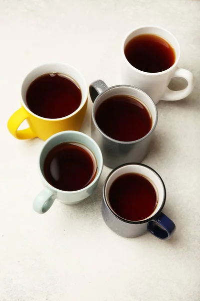 Black tea (coffee) in bright cups, office break, team building.