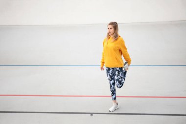 Eğitimden önce kaslarını ısıtan çekici bir kadın. Yaşam tarzı olarak spor ve spor. Atletik açık hava.