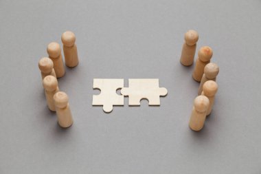 Gri arkaplanlı ahşap figürler. İş adamları arasındaki anlaşma, işbirliği ve anlaşma konsepti. Başarılı bir sözleşme.. 