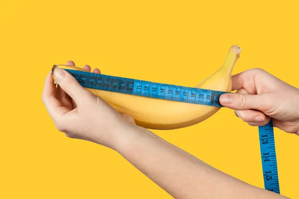 Measuring the size of a banana as a symbol of the male penis. Big dick length. Strong erection and impotence problem.