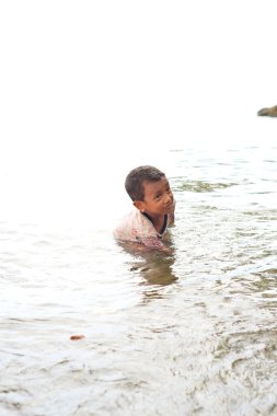 Sahilde bir çocuk oynuyor.