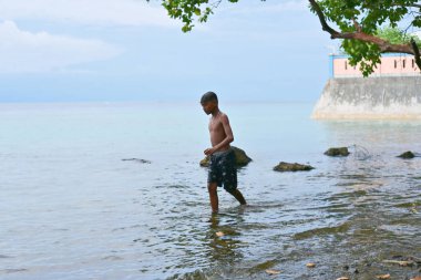 Bir çocuk sahilde oynuyor