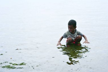 Maluku, Endonezya - 2 Mart 2024: Sahilde bir çocuk oynuyor