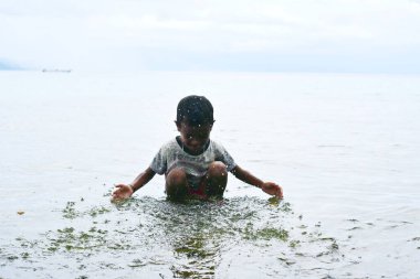 Maluku, Endonezya - 2 Mart 2024: Sahilde bir çocuk oynuyor