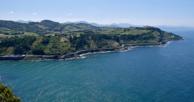 Dağlar ve yeşil çayırlar ile yaz aylarında deniz kıyısı.