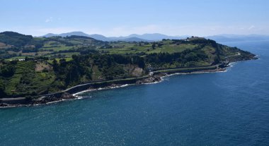 Dağlar ve yeşil çayırlar ile yaz aylarında deniz kıyısı.