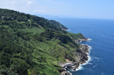 Dağlar ve yeşil çayırlar ile yaz aylarında deniz kıyısı.