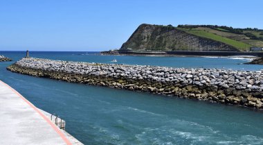 Bir tahta kaldırımdan kayalıklarla sahil manzarası.