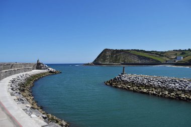 Bir nehrin denize giriş ve çıkışı, bir plajın yanında.