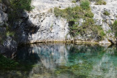Kireçtaşı dağları arasında mavi ve kristal berraklığında su gölü.