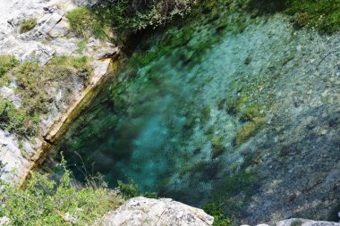 Kireçtaşı dağları arasında mavi ve kristal berraklığında su gölü.