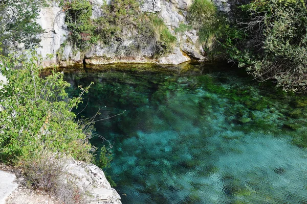 Kireçtaşı dağları arasında mavi ve kristal berraklığında su gölü.