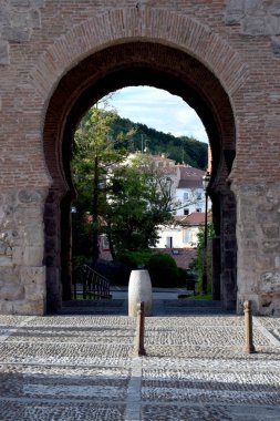 Bir duvarın kapısından şehrin görünümü.