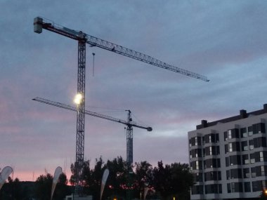 Gün batımında binaların ve ağaçların silueti.