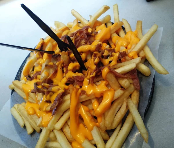 Potato Chips Cheese Sauce Black Plate — Stock Photo, Image