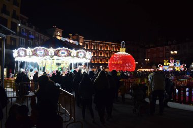 Bir meydanda ışıklı noel topu ve noel ışıkları.