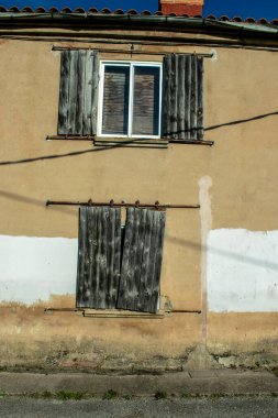 Eski kapı ve pencereli taş duvar.