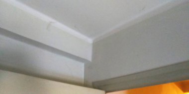 Beyaz duvarlı bir odanın köşesinde..